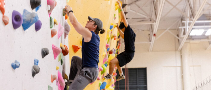 students climbing indoor rock wall